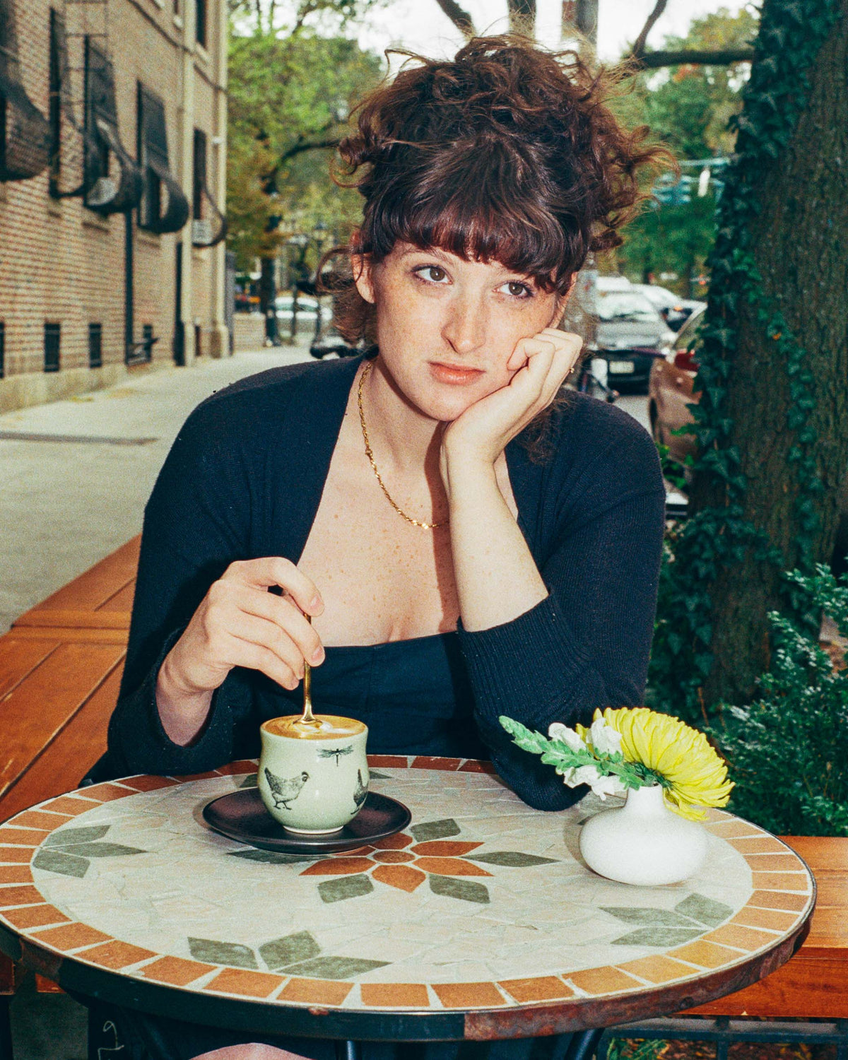 Emilee Bryant sitting with a coffee behind a table in an outside café