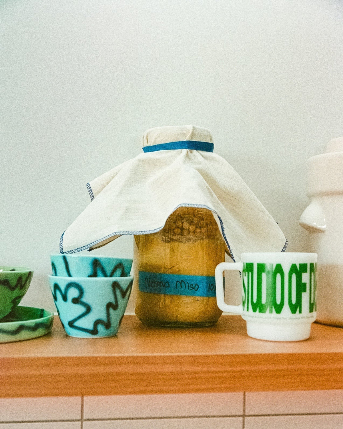 Coffee cups next to a homemade stored miso soup in a jar