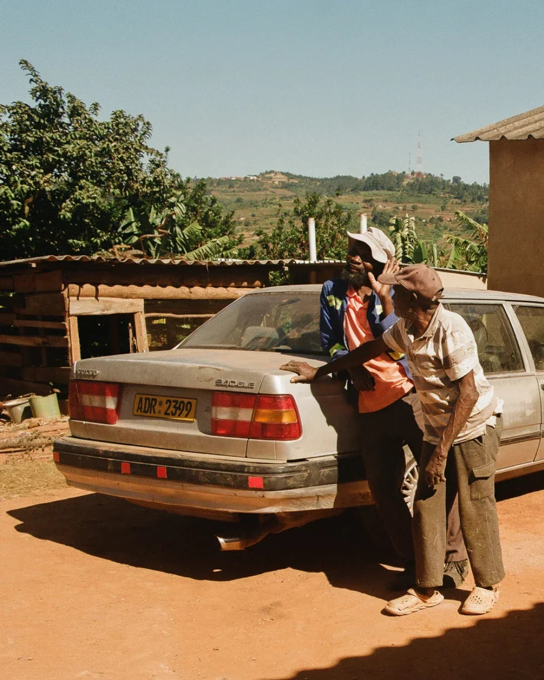 Two men in Zimbabwe leaning on an old Volvo