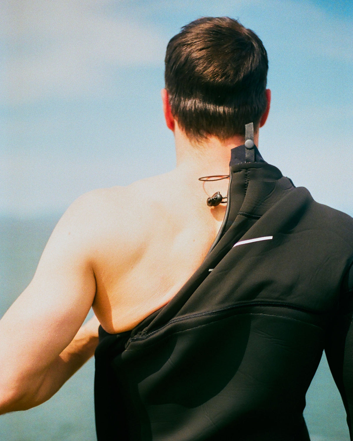 Noah Lane in a swim overall from behind